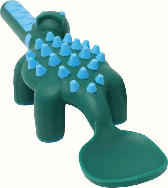 Dinosaur-themed children's utensil set by Constructive Eating. The green spoon features a dinosaur shape with blue accents and raised spikes, designed to make mealtime fun and engaging for kids.