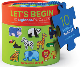 A cylindrical puzzle container titled 'Let's Begin Jungle' featuring cartoonish animal illustrations on its sides. The container comes with a blue tag reading '10 beginner puzzles' and shows playful images of a hippo, panda, toucan, zebra, giraffe, and other jungle animals, designed to engage young children in early puzzle-solving skills.
