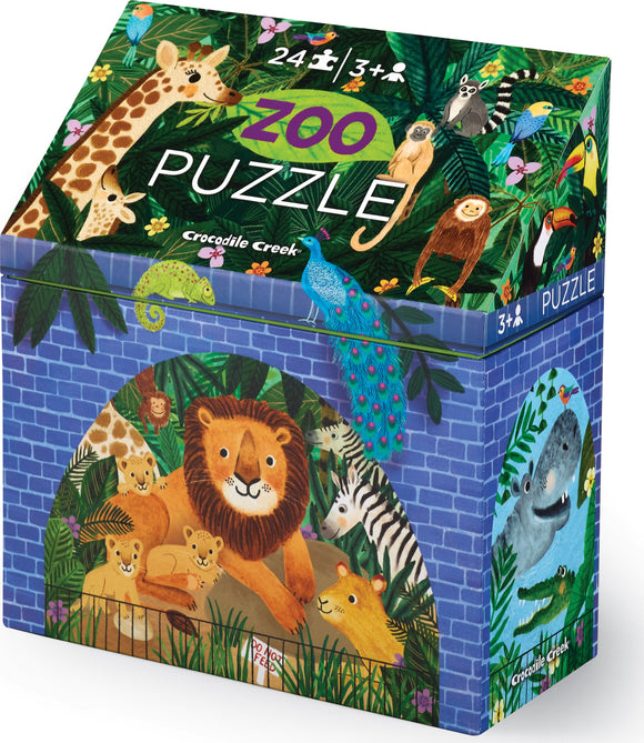 Crocodile Creek Puzzle Zoo jigsaw puzzle with 24 colorful pieces featuring a lion and its cubs, surrounded by tropical foliage and various animals. The box showcases whimsical illustrations of a giraffe, peacock, monkey, and more, appealing to young children aged 3 and up.
