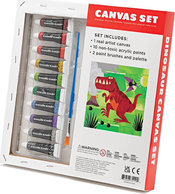 Crocodile Creek Canvas Art set featuring a Dinosaur theme. The set includes one artist canvas, ten non-toxic acrylic paint tubes in various colors, two paint brushes, and a palette. The packaging showcases a vibrant dinosaur illustration, appealing to young artists and dinosaur enthusiasts.