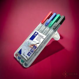 A pack of four water-soluble markers in red, blue, green, and black colors, displayed against a gradient background. The markers are in a transparent casing and are labeled 'Water Soluble 4 Markers' by Chessex, showcasing their ideal use for games and crafts.