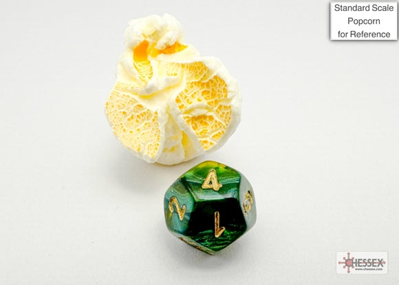 A Scarab Mini polyhedral die in jade and gold colors, displaying numbers on its faces. Accompanied by a piece of popcorn for size reference, showcasing its unique design and craftsmanship by Chessex.