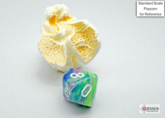 Festive mini poly waterlily die by Chessex, featuring a vibrant blend of green, blue, and purple colors with white numbers. The die is shown alongside a piece of popcorn for scale.
