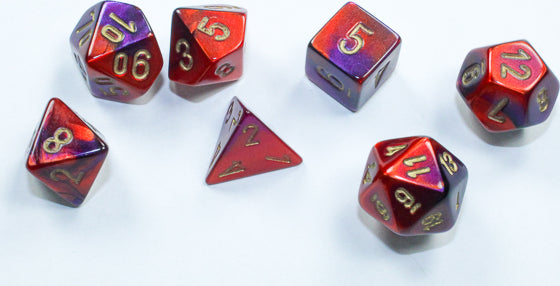A set of seven Mini Gemini RPG dice featuring a vibrant purple-red color with gold numbering. The dice include various shapes such as d4, d6, d8, d10, d12, and d20, perfect for tabletop gaming.