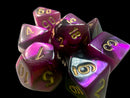 A collection of Mini Gemini RPG Dice in a striking black, purple, and gold color scheme. The dice exhibit sparkling translucent hues, with gold numbers prominently displayed on each face. This set includes a variety of polyhedral dice, perfect for tabletop role-playing games.