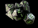 A collection of Mini Gemini RPG dice in a black-grey and green color scheme. The set includes various polyhedral shapes like d4, d6, d8, d10, d12, and d20, featuring vibrant green numbers that stand out against the dark, glossy surface of the dice. Ideal for tabletop gaming, these dice add a striking touch to any RPG game.