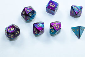 A set of Mini Gemini RPG dice featuring vibrant purple and teal colors with gold numbering. The set includes various polyhedral dice, ideal for tabletop gaming.