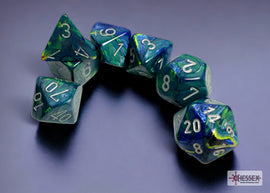 A set of six polyhedral dice in festive green and silver colors. The dice include a tetrahedron (4-sided), octahedron (8-sided), dodecahedron (12-sided), and icosahedron (20-sided) featuring clear and swirled patterns. Each die displays embossed numbers along the sides, showcasing a shimmering finish that adds to the visual appeal.