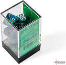 A clear acrylic container holding a set of festive green and silver polyhedral dice from Chessex. The dice are displayed with various numbers visible, showcasing their vibrant color blend.