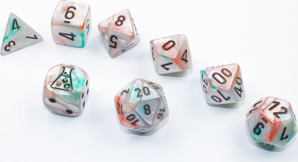 A 7-piece dice set by Chessex featuring lustrous sea shell and black luminary colors. The set includes various polyhedral dice such as a d4, d6, d8, d10, d12, and d20, with clear markings for easy gameplay. The translucent material reflects light beautifully, enhancing any tabletop game experience.