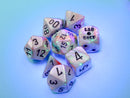 Chessex LAB DICE 7-piece dice set featuring lustrous seashell and black luminary colors. Includes various polyhedral dice with clear numbers, set against a soft colored background.