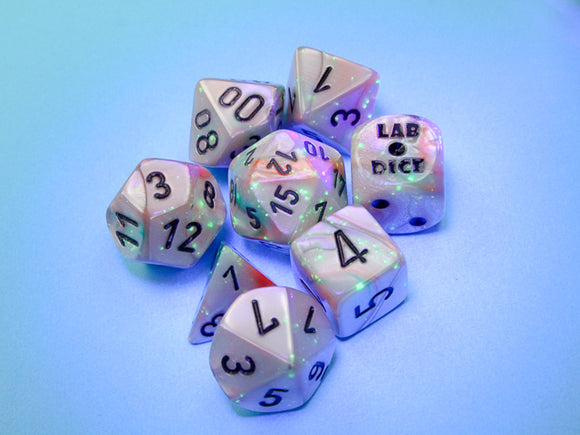 Chessex LAB DICE 7-piece dice set featuring lustrous seashell and black luminary colors. Includes various polyhedral dice with clear numbers, set against a soft colored background.