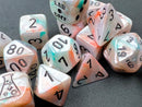 A vibrant 7-piece polyhedral dice set by Chessex, featuring lustrous sea shell and black luminary colors. The dice include various shapes, such as d4, d6, d8, d10, d12, and d20, all with bold black numerals. The set is artistically arranged, showcasing the iridescent finish and unique patterns of each die, perfect for tabletop games and RPG enthusiasts.