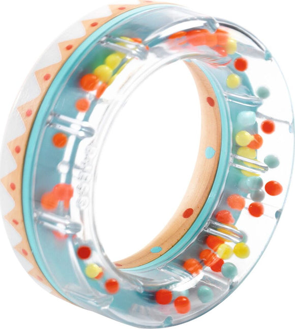 The BabyRing from DJECO is a colorful sensory toy designed for babies. It features a transparent outer ring filled with small beads in various colors, including orange, yellow, and blue, which create engaging sounds and movement as the ring is shaken or rolled. The inner wooden circle is decorated with fun polka dots, enhancing visual stimulation and tactile exploration. Perfect for improving motor skills and providing sensory entertainment for infants.