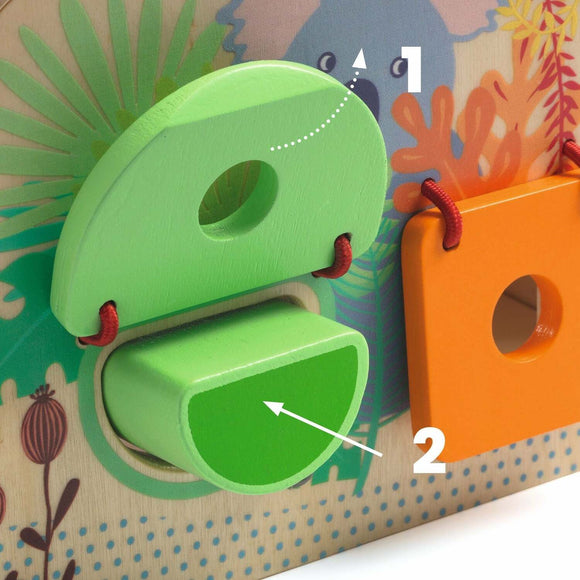 An educational toy featuring colorful wooden shapes designed for children. The image shows a green half-moon shape being positioned into a matching slot on a vibrant puzzle board, complete with playful illustrations of flora and fauna in the background.