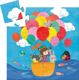 A colorful jigsaw puzzle featuring a hot air balloon scene with cheerful animal characters including a bear, a rabbit, and a playful cat, surrounded by vibrant balloons and a bright blue sky. The puzzle is partially assembled, showcasing the bright colors and whimsical artwork typical of DJECO products.