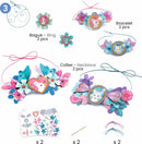 The Nymphea Multi Activity Kit by DJECO features colorful crafting materials, including a bracelet, necklace, and rings adorned with flowers and butterflies. It showcases creativity and encourages hands-on activities for children, perfect for developing fine motor skills and imaginative play.