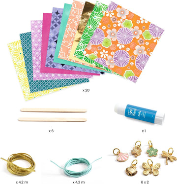 A DIY kit from DJECO featuring colorful paper sheets, pink and gold floral designs, adhesive glue, six wooden sticks, gold and aqua wires, and charm accessories shaped like butterflies, seashells, and flowers. Perfect for making personalized paper beads and bracelets.