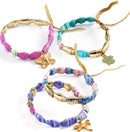 A collection of colorful paper bead bracelets made by DJECO. Each bracelet features a mix of vibrant paper rolls and shiny gold accents. Some have decorative charms like a butterfly and a flower, showcasing a creative DIY craft perfect for kids.