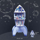 A colorful DIY kit of a space rocket featuring multiple levels and an astronaut figurine. The rocket includes illustrated interiors with tables and chairs, designed to inspire imaginative play and creativity. Dimensions shown are 53 cm tall and 25 cm wide.