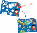 A colorful DIY art kit titled 'Hidden in the Sky Paint' by DJECO. The image shows a vibrant blue background featuring playful illustrations of rockets, stars, and friendly creatures. A red marker is shown pointing towards a panel that reveals hidden designs when colored, encouraging creativity and imaginative play.