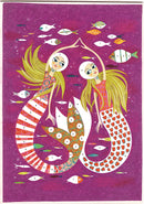 Mermaid Lights Glitter Boards by DJECO featuring two beautifully illustrated mermaids with flowing hair surrounded by colorful fish on a vibrant purple background. This DIY kit encourages creativity and artistic expression.