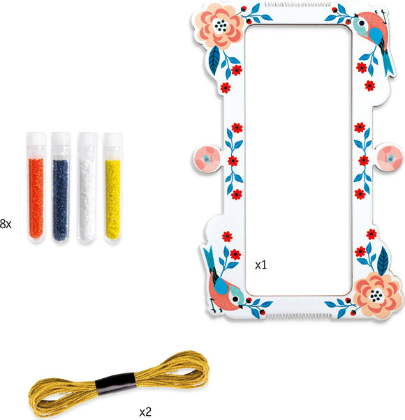 DJeco Tiny Beads & Jewelry DIY kit featuring a decorative frame adorned with flowers and birds. Includes 8 tubes of colorful beads (orange, blue, white, yellow) and 2 lengths of string for crafting unique jewelry pieces.