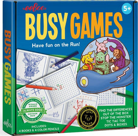 Busy Games Travel Set by Eeboo includes four illustrated activity books and four colored pencils. The packaging features vibrant colors and playful illustrations of characters like monsters and animals. The game encourages fun activities such as finding differences, playing tic-tac-toe, and dots and boxes.