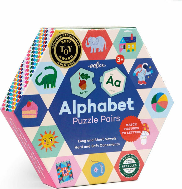 Hexagon-shaped box of Eeboo's Alphabet Puzzle Pairs featuring colorful illustrations representing letters and words. The packaging emphasizes matching pictures to letters, with highlights on vowels and consonants. Recommended for ages 3 and up, it carries a Best Toy Award seal.
