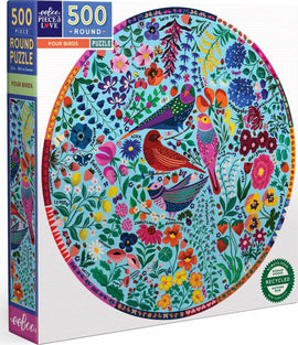 Eeboo's Four Birds round jigsaw puzzle featuring a vibrant and colorful illustration of various birds surrounded by a variety of flowers and plants. The puzzle contains 500 pieces and is designed for ages 3 and up. The box showcases the round puzzle image and includes labels indicating it is made from recycled materials and is woman-owned.