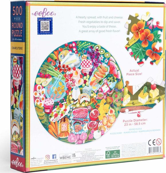 Eeboo Charcuterie 500-piece round jigsaw puzzle featuring an array of colorful foods, including fruits, vegetables, cheeses, and snacks, displayed on a vibrant platter. The puzzle has a diameter of 23 inches (58.5 cm) and includes a sample of the actual puzzle piece size on the side.