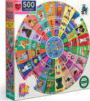 The Dogs of the World Round Puzzle by Eeboo features 500 colorful pieces arranged in a circle, showcasing various dog breeds and their names from around the globe. The vibrant design highlights distinct dog illustrations and flags representing different countries. The puzzle is packaged in a sturdy box, perfect for family fun and educational play.