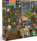 The Alchemist's Library jigsaw puzzle features a richly detailed scene with a cozy study filled with books, a globe, and various artifacts. A woman writes at a desk while a girl looks through a telescope, and a cat rests peacefully in the foreground. The puzzle consists of 1000 pieces and measures 23 x 32 inches.