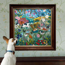 A wooden-framed jigsaw puzzle titled 'English Hedgerow' by Eeboo, depicting a vibrant and colorful countryside scene filled with various animals, flowers, and greenery. A small dog is seen curiously looking at the puzzle which is hung on a patterned wall, accentuating the artistic details of the piece.