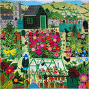 A colorful jigsaw puzzle depicting a vibrant garden scene. The puzzle features a variety of blooming flowers in shades of pink, yellow, and red, alongside lush greenery. In the background, there are greenhouses and a black garden shed, with a quaint village and hills visible in the distance. Gardeners are seen tending to the plants, adding to the lively atmosphere of the garden activity.