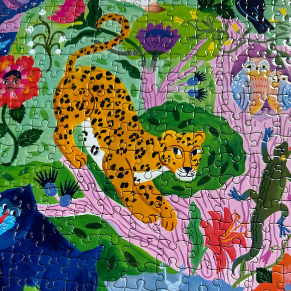 A vibrant 1000-piece jigsaw puzzle titled 'Life in a Tree' by Eeboo featuring a colorful and playful illustration of a spotted leopard, lush greenery, flowers, animals, and whimsical characters. The pieces are interlocked, showcasing the artwork's intricate details and vivid colors.