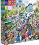 A vibrant 1000-piece jigsaw puzzle titled 'Paris Bookseller' by Eeboo. The box features a colorful illustration of a Parisian street filled with bustling crowds, book vendors, and classic cars. The scene showcases an iconic Parisian architecture in the background, including trees and various people dressed in stylish outfits, enhancing the charm of a lively Parisian market.