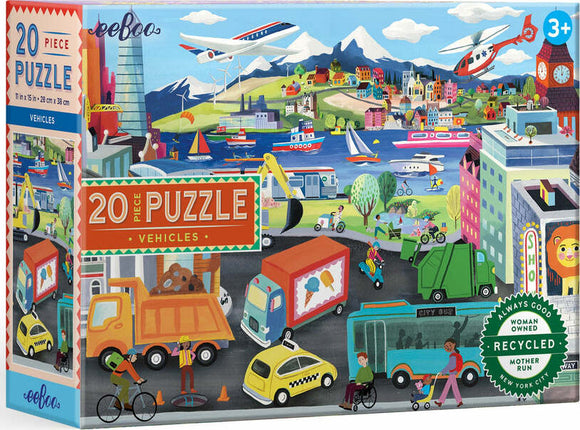 Eeboo 20 Piece Jigsaw Puzzle featuring a vibrant, illustrated scene of various vehicles in action, including trucks, boats, and helicopters, set against a colorful backdrop of buildings, mountains, and trees. The puzzle is designed for children ages 3 and up, promoting cognitive development and creativity.