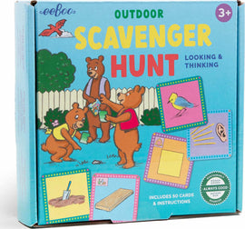 The Scavenger Hunt Game by Eeboo features a colorful box with illustrations of three bears engaging in a playful outdoor scavenger hunt. The box is bright blue and displays the words 'OUTDOOR SCAVENGER HUNT' prominently. It indicates that the game includes 50 cards and instructions, suitable for ages 3 and up. The sides of the box showcase various activities related to the scavenger hunt, like identifying birds and digging.