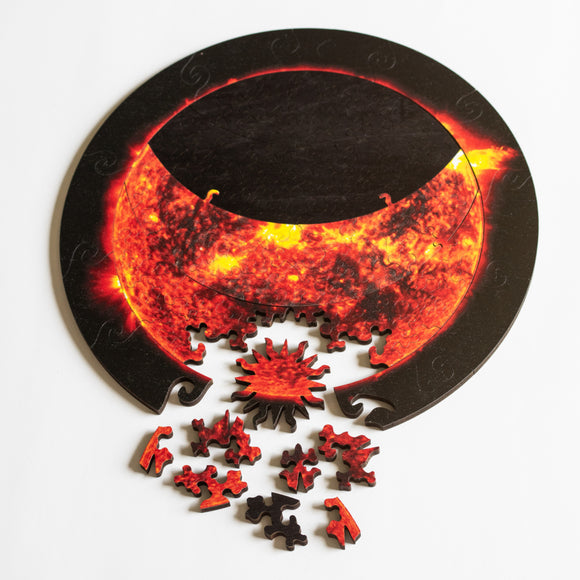 Jigsaw showing partial eclipse with sun-shaped whimsey piece and other pieces