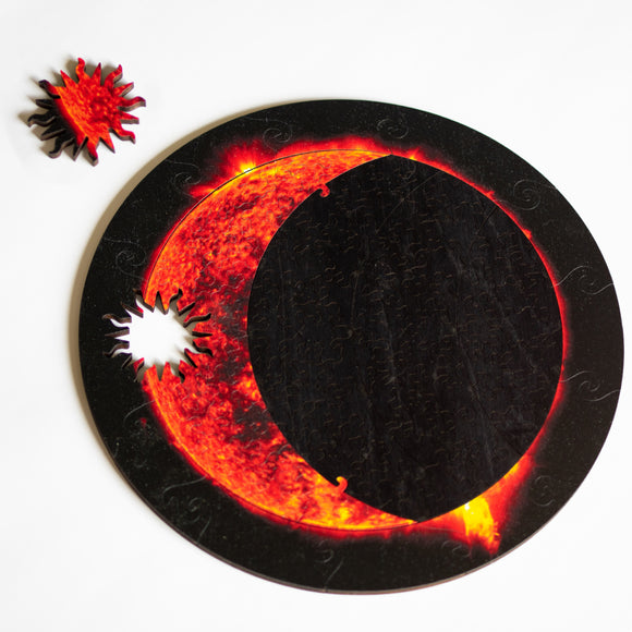 Jigsaws showing partial eclipse with sun-shaped whimsy piece