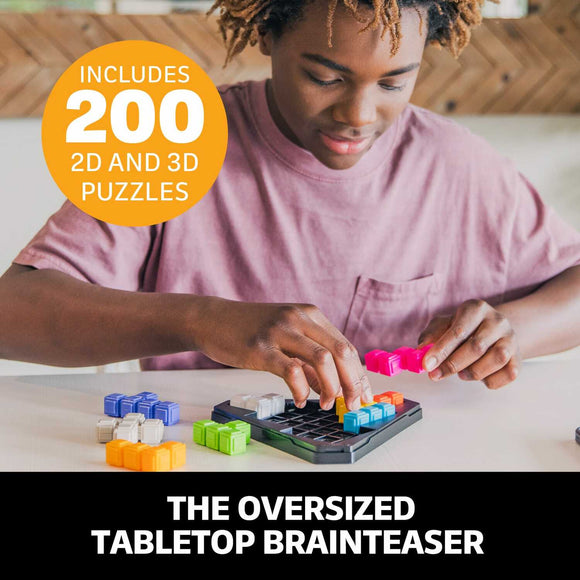 A young person concentrates on assembling colorful puzzle pieces from the Kanoodle Pyramid mechanical puzzle set, which includes 200 different 2D and 3D challenges. The table is scattered with vibrant pieces in various shapes as they solve the oversized tabletop brainteaser.