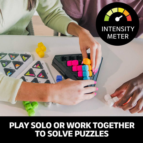 Two people engaging with the Kanoodle Pyramid mechanical puzzle from Educational Insights. One person is placing colorful pieces into the triangular base, while the other holds additional pieces. The action is lively, suggesting collaboration and problem-solving, with colorful blocks scattered around.