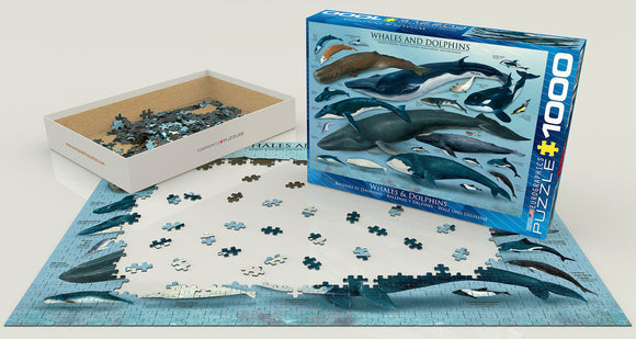 A 1000-piece jigsaw puzzle titled 'Whales & Dolphins' by Eurographics. The image shows the puzzle box with a colorful illustration of various whales and dolphins, alongside pieces scattered on the table and a partially completed puzzle showing the ocean scene.