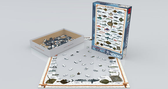 A jigsaw puzzle titled 'Sea Fish' by Eurographics, depicting an array of fish species. The partially completed puzzle shows an ocean-themed design with various fish pieces scattered across the surface and the puzzle box standing next to it, featuring vibrant images of different fish.