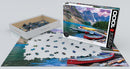 A Eurographics jigsaw puzzle titled 'Canoes on the Lake'. The image shows an array of colorful canoes on a serene lake surrounded by mountains. The puzzle is partially assembled, with scattered pieces still in the tray and on the table. The box displays a vibrant, picturesque scene capturing the beauty of the outdoors.