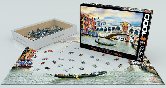 Eurographics jigsaw puzzle featuring the iconic Rialto Bridge in Venice. The image shows the puzzle pieces scattered around the partially assembled puzzle depicting the beautiful bridge and surrounding architecture, with the box prominently displaying the finished artwork.
