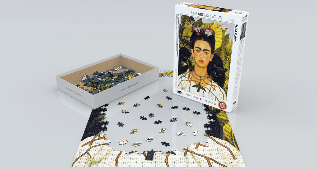 Self-Portrait with Thorn Necklace jigsaw puzzle by Eurographics. The image features Frida Kahlo's iconic portrait surrounded by green foliage. The puzzle includes various scattered pieces in a box, showcasing vibrant colors and details.