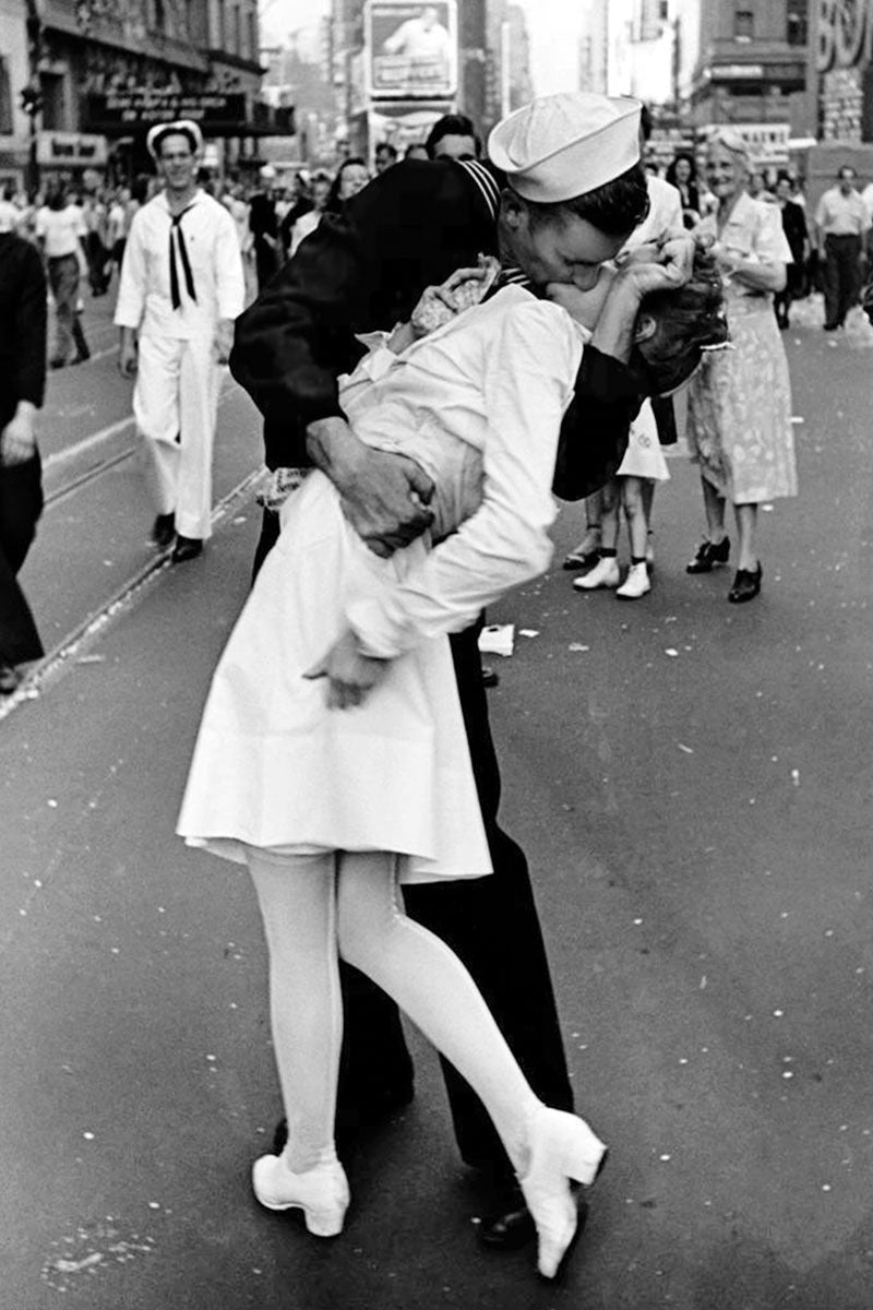 A jigsaw puzzle featuring the iconic V-J Day kiss in Times Square. The image captures a sailor passionately kissing a nurse amidst a crowded street celebration, showcasing joy and relief at the end of World War II.