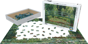 A jigsaw puzzle featuring Claude Monet's artwork 'The Japanese Footbridge'. The image shows the box with a vibrant painting of a serene footbridge surrounded by colorful flowers and lush greenery. The puzzle pieces are scattered around, with a partially completed puzzle on a white surface.